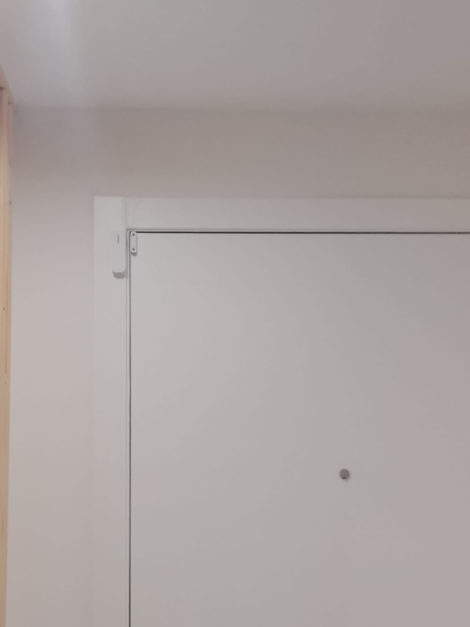Contacto magnético instalado en el marco de la puerta de entrada de una vivienda en Manises