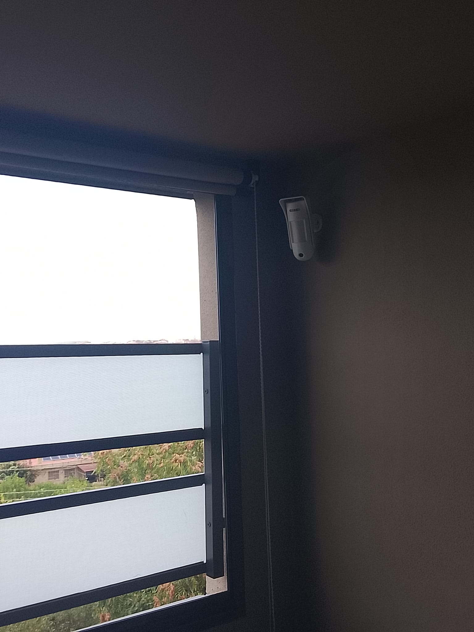 Detector de movimiento orientado hacia el exterior junto a una ventana, en una vivienda en Manises