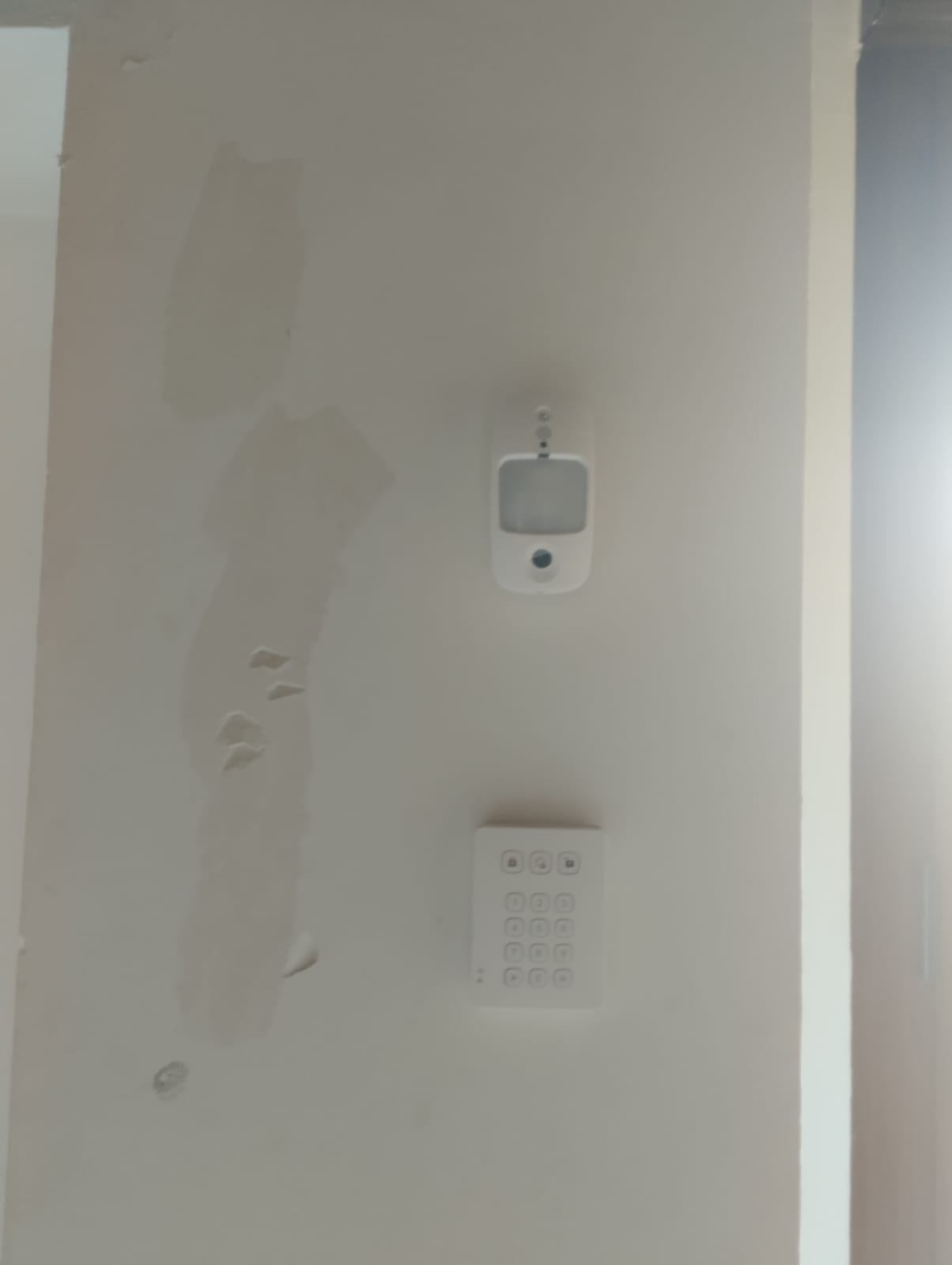Detector de movimiento y teclado del kit antiocupas vía radio instalados en la pared de una vivienda en Ontinyent