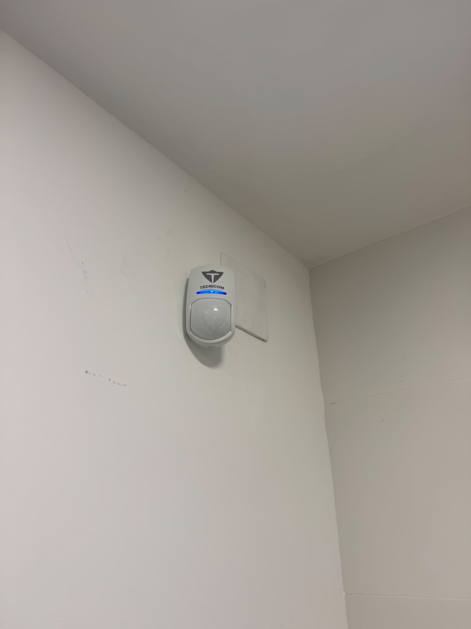 Detector de movimiento con el logo de Tecnicom instalado en una esquina de la vivienda de Turís